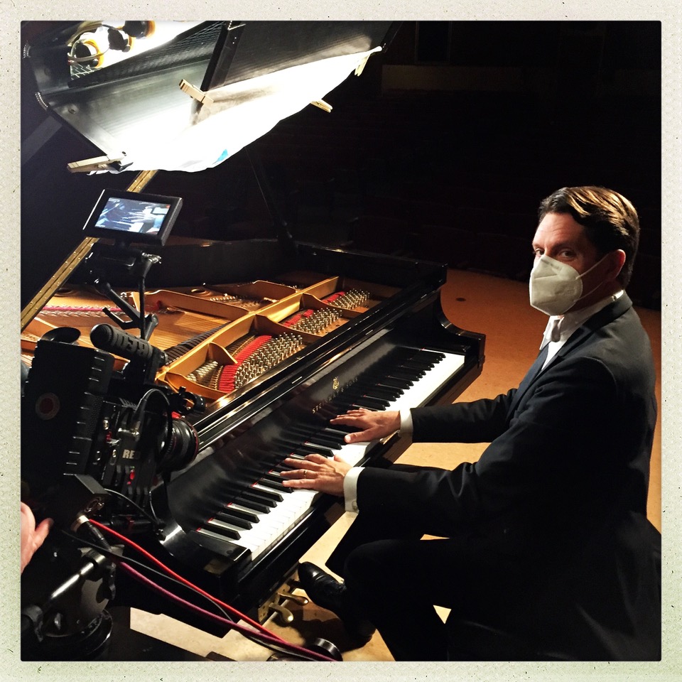 man in mask playing piano